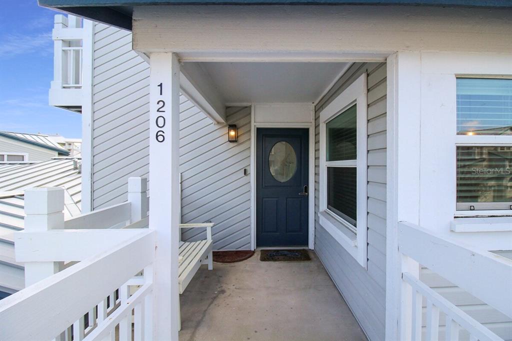 A covered porch leads to a dark blue front door with a glass oval window — 1206 SIESTA BAYSIDE DRIVE UNIT 1206B, SARASOTA, FL