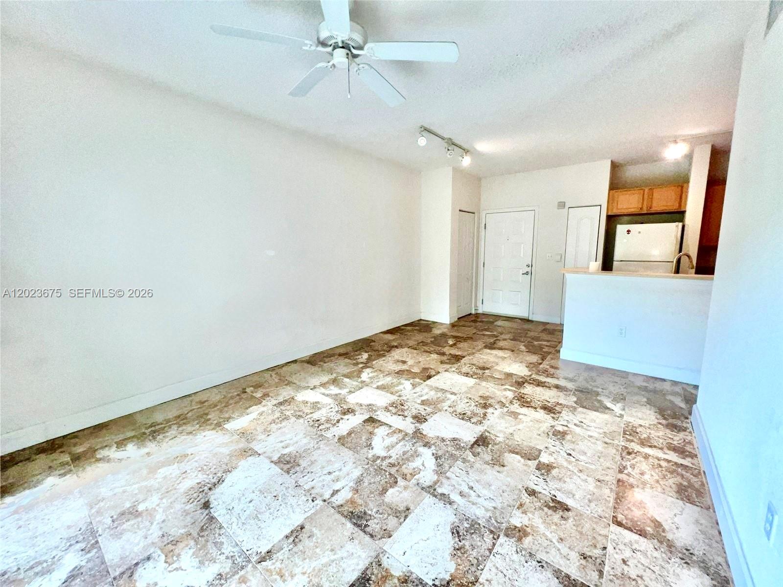 An open living area features a ceiling fan, track lighting, and brown patterned tile flooring — 6001 SW 70th St # 454, South Miami FL 33143, SOUTH MIAMI, FL