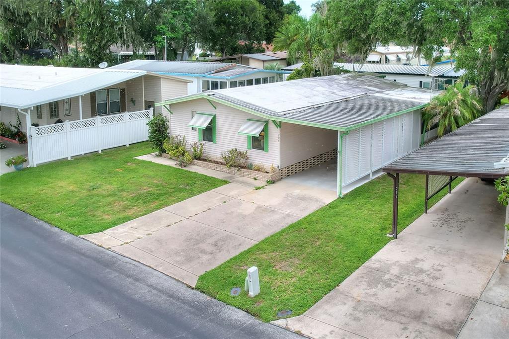 An exterior view of a single-story mobile home with a carport and concrete driveway — 2055 S FLORAL AVENUE UNIT 296, BARTOW, FL