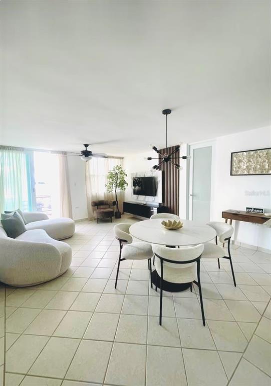 A dining area with a round table and chairs sits in an open-concept living space — 306 OCEAN WALK CHALETS, LUQUILLO, PR
