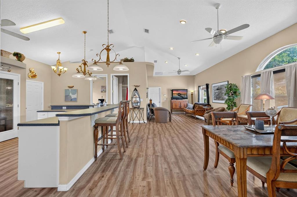 A hallway with wood-look flooring leads to an open-concept living area with vaulted ceilings — 497 GRANDVIEW AVENUE, ORMOND BEACH, FL