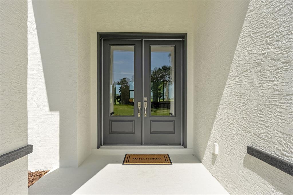 A dark gray double front door with glass panels sits under a covered entryway — 10264 S LECANTO HIGHWAY, LECANTO, FL