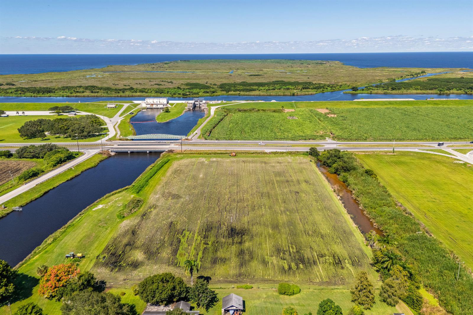An aerial view shows a large agricultural field, a canal, a road, and a lock system — 0 Us-27, Clewiston FL 33440, CLEWISTON, FL