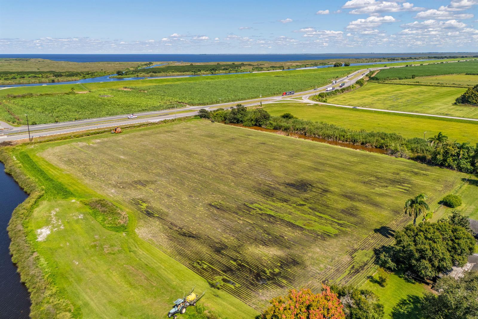 An aerial view shows a large, tilled agricultural field bordered by a road and canal — 0 Us-27, Clewiston FL 33440, CLEWISTON, FL