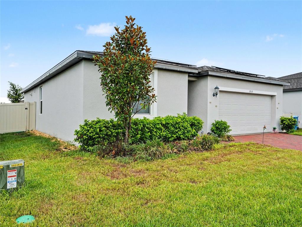 A modern kitchen features white cabinetry, granite countertops, a central island, and tile flooring — 2019 KINGSMEN COURT, HAINES CITY, FL