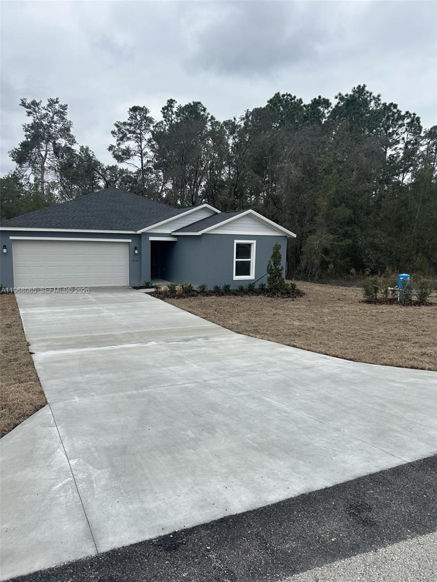 A single-story house with a gray exterior, a two-car garage, and a concrete driveway — 8934 SW 135TH ST, Ocala FL 34473, OCALA, FL
