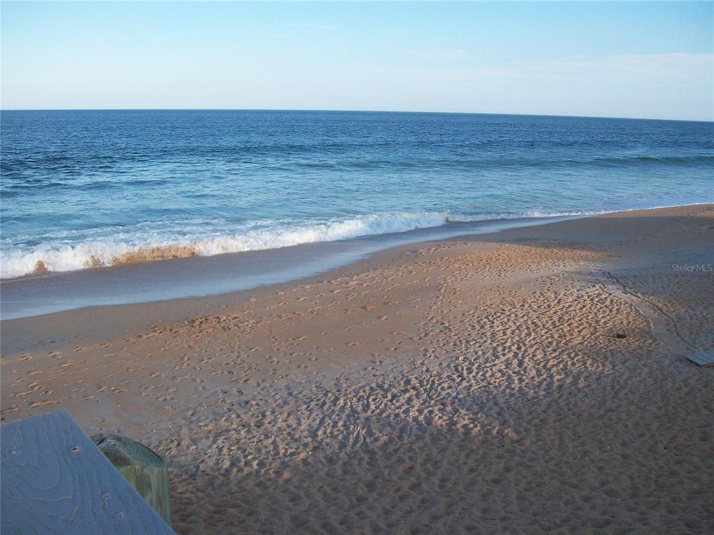 A view of a sandy beach and the ocean from an elevated wooden deck — 169 LOOKOUT DRIVE, FLAGLER BEACH, FL