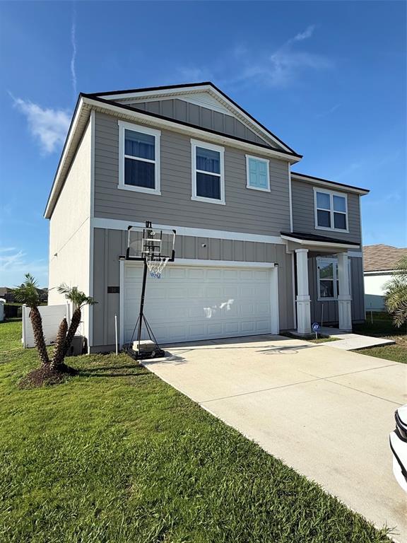 A two-story house with gray siding, a white garage door, and a basketball hoop — 38 HULETT WOODS ROAD, PALM COAST, FL