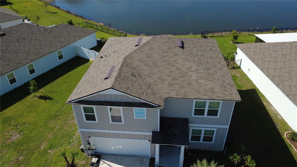 An aerial view shows the roof and front exterior of a two-story suburban house — 38 HULETT WOODS ROAD, PALM COAST, FL