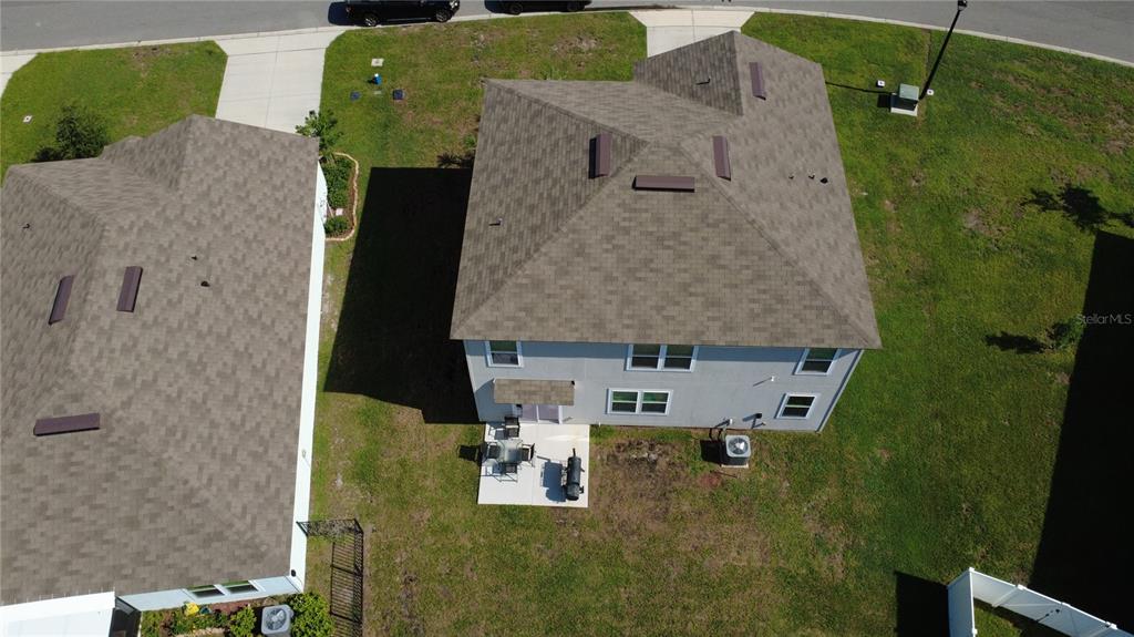 An aerial view shows the back of two suburban houses with shingled roofs and yards — 38 HULETT WOODS ROAD, PALM COAST, FL