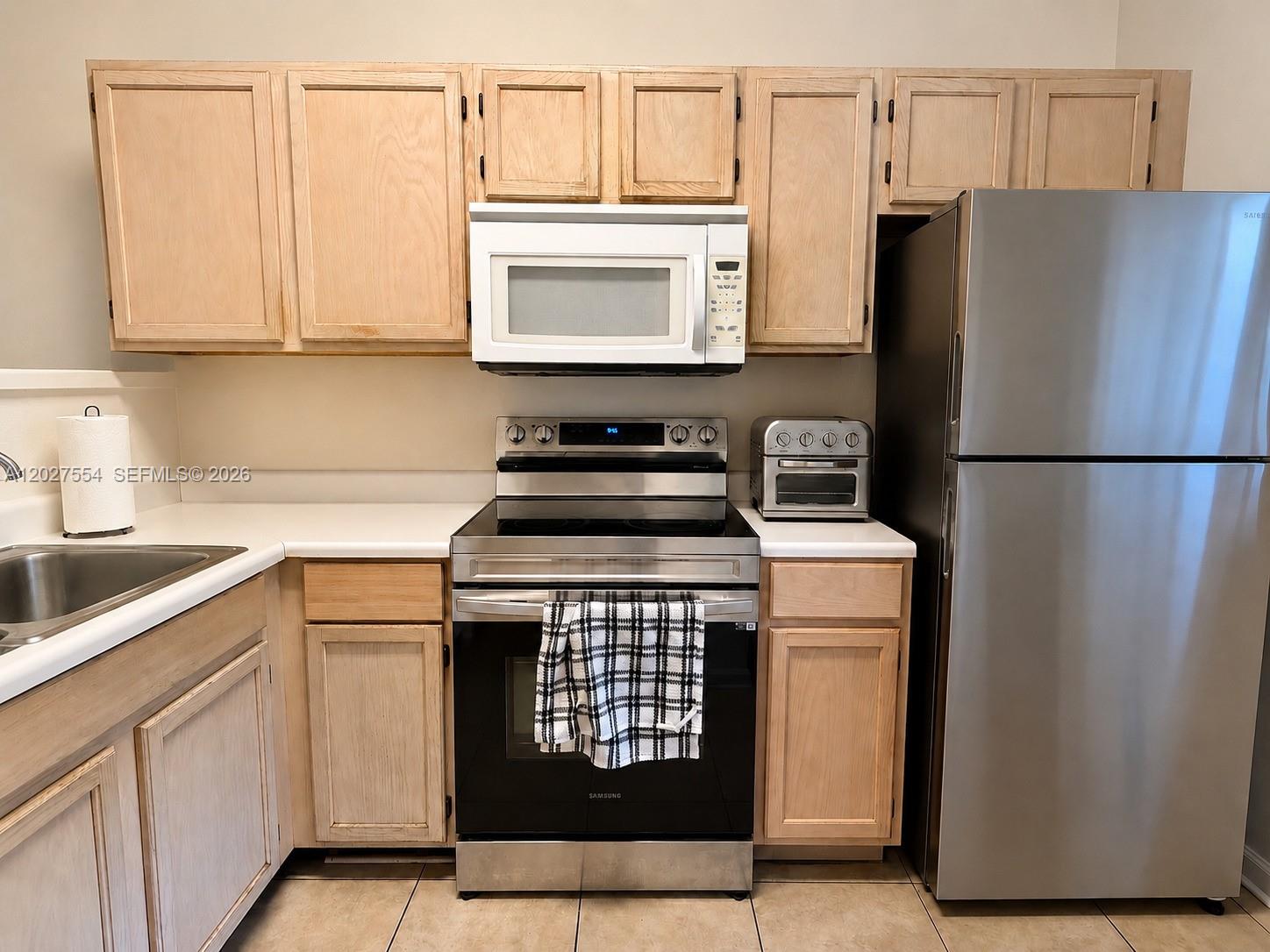 A kitchen features light wood cabinets, stainless steel appliances, and white countertops — 3680 NW 91st Ln # 3680, Sunrise FL 33351, SUNRISE, FL