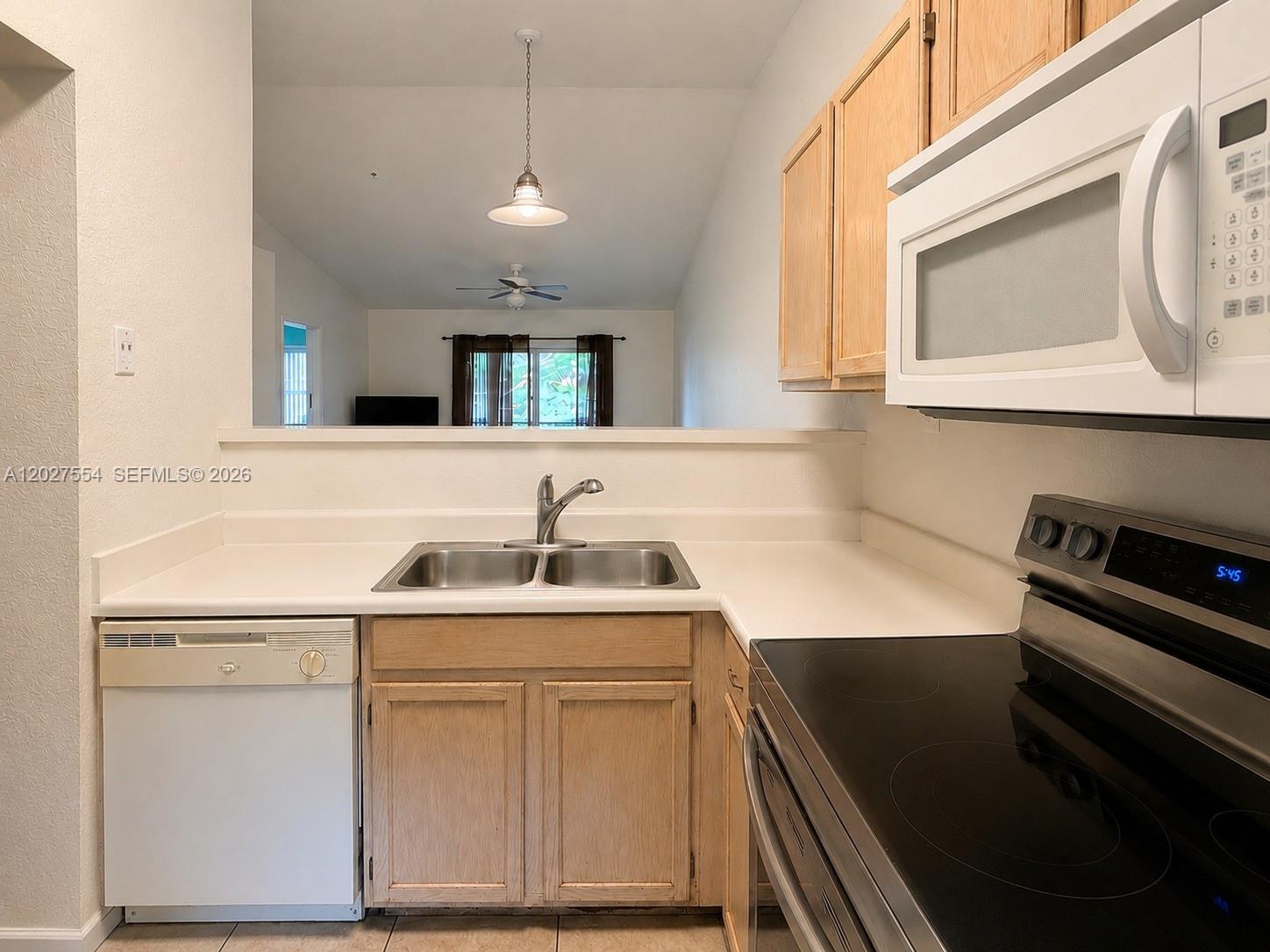 A kitchen features light wood cabinets, white countertops, a double sink, and white appliances — 3680 NW 91st Ln # 3680, Sunrise FL 33351, SUNRISE, FL