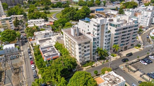 An aerial view shows multi-story apartment buildings surrounded by trees, streets, and a nearby highway — 1422 WILSON AVENUE AVENUE UNIT 5B, SAN JUAN, PR