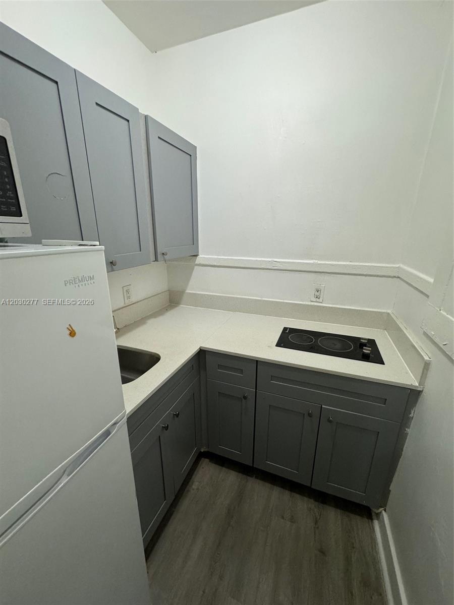 A small kitchen features gray cabinets, a white countertop, a sink, and a cooktop — 1552 SW 2nd St # 3, Miami FL 33135, MIAMI, FL