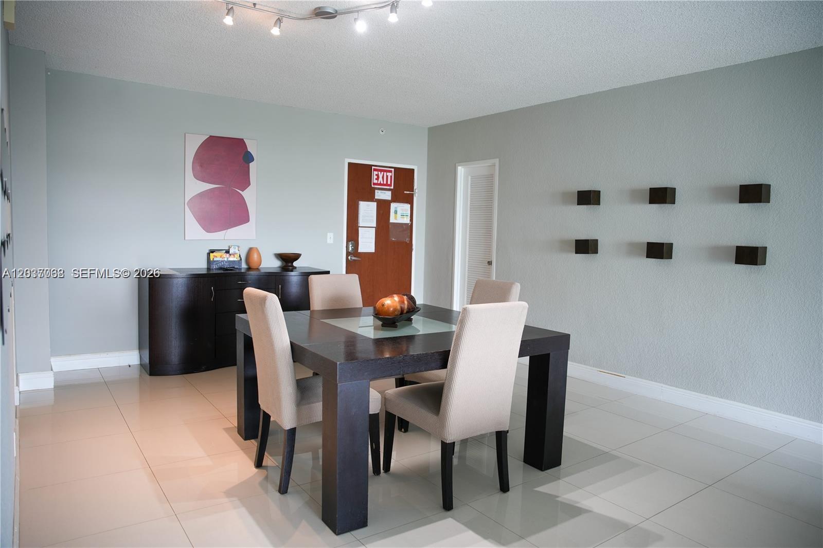 A dining room features a dark wood table, four upholstered chairs, and light tile flooring — 4001 S Ocean Dr # 11A, Hollywood FL 33019, HOLLYWOOD, FL