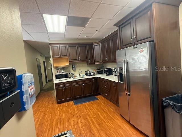 A kitchen features dark wood cabinets, stainless steel appliances, and wood-look flooring — 326 N MILLS AVENUE, ORLANDO, FL