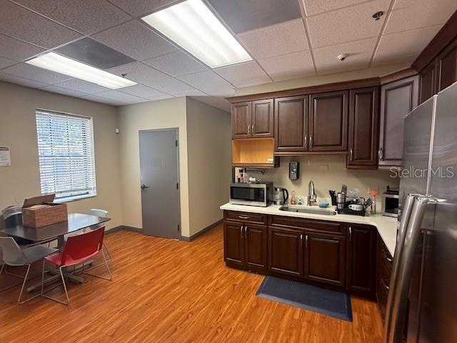 A breakroom features dark wood cabinets, a stainless steel refrigerator, and a dining table — 326 N MILLS AVENUE, ORLANDO, FL