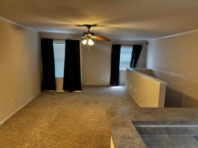 An open living area features beige carpet, a ceiling fan, and dark window curtains — 4850 51ST STREET W UNIT 4207, BRADENTON, FL