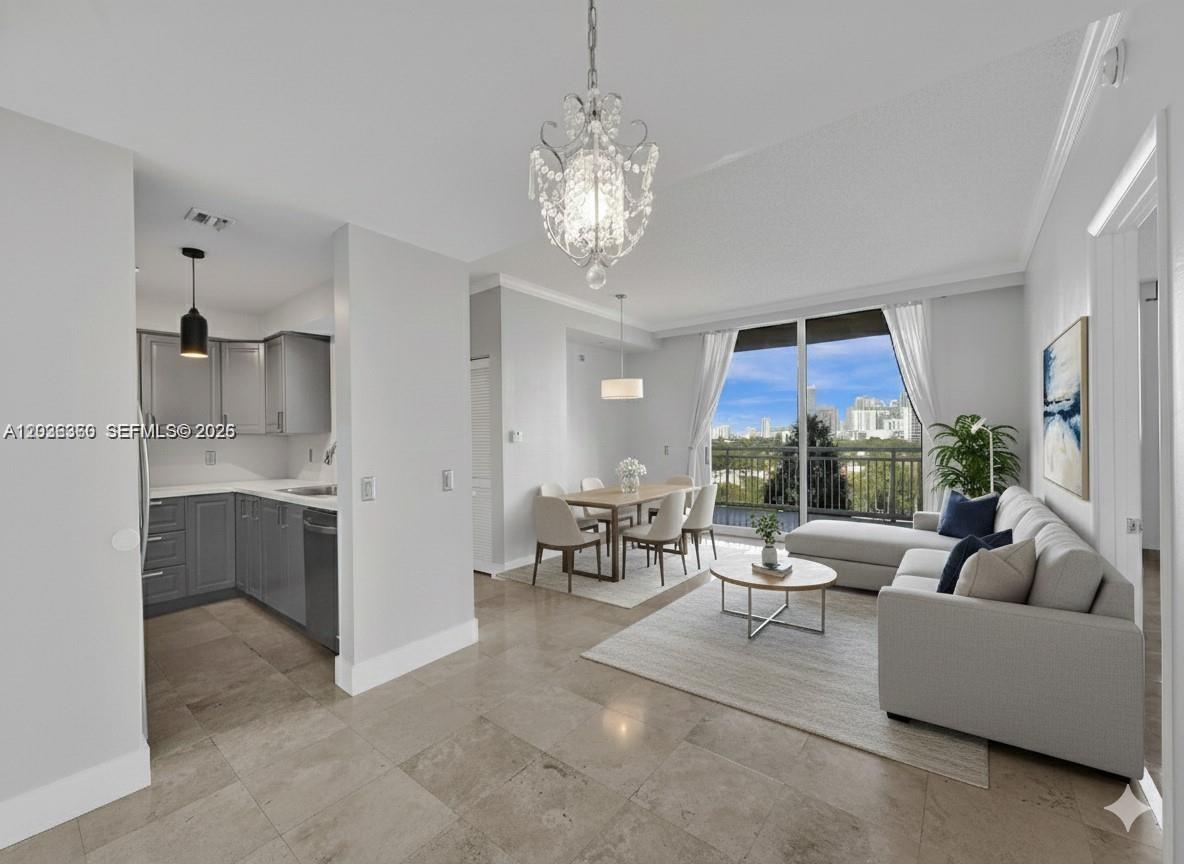 An open-concept living and dining area features gray cabinetry, tile flooring, and a balcony view — 2475 Brickell Ave # 804, Miami FL 33129, MIAMI, FL