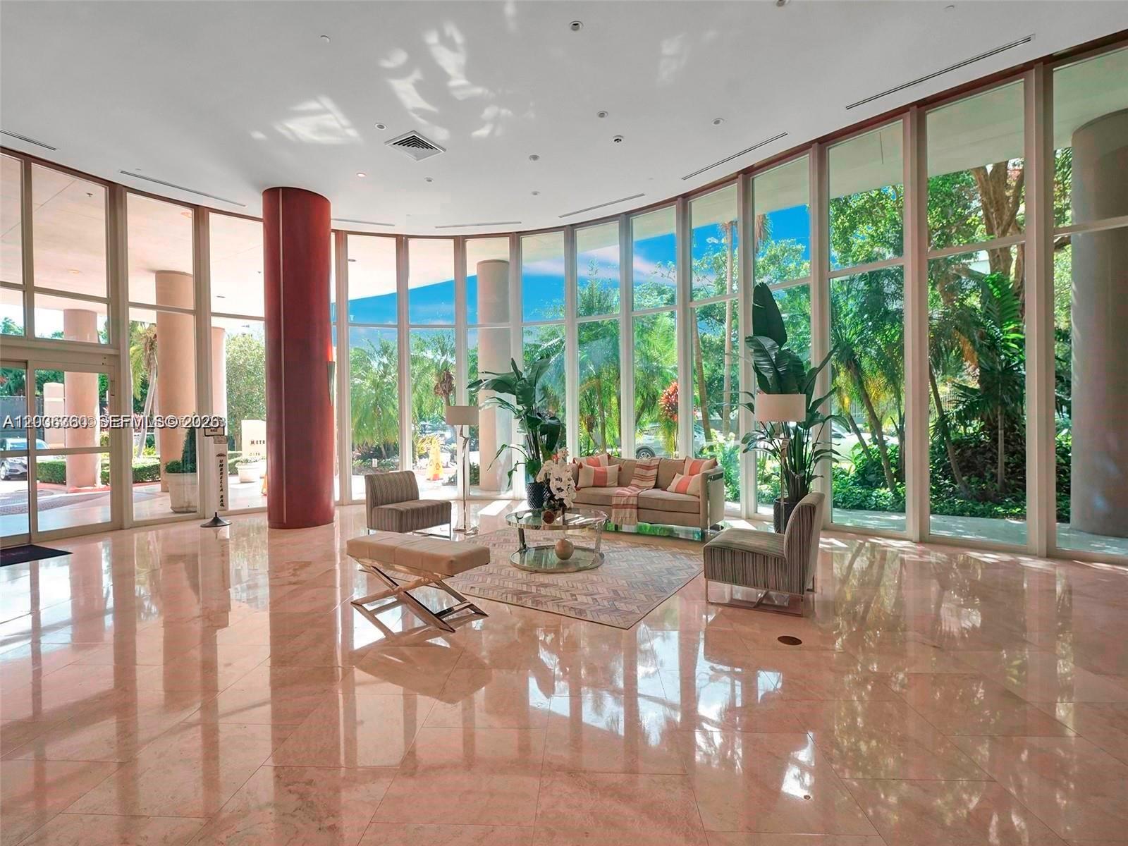 A bright, spacious lobby features polished marble floors, floor-to-ceiling windows, and contemporary seating areas — 2475 Brickell Ave # 804, Miami FL 33129, MIAMI, FL