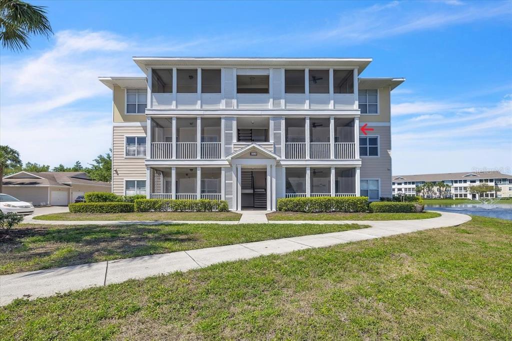 A three-story apartment building with screened balconies and a sidewalk leading to the entrance — 4802 51ST STREET W UNIT 1916, BRADENTON, FL