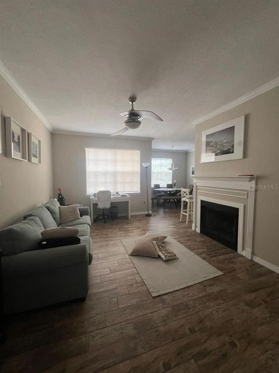 A living room features a gray sofa, a fireplace, and a desk near a window — 2632 ROBERT TRENT JONES DRIVE UNIT 134, ORLANDO, FL