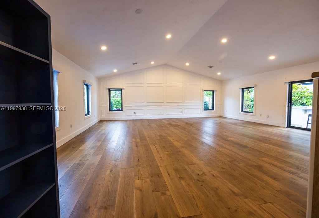 A spacious, empty room features light-colored walls with wainscoting, recessed lighting, and wood flooring — 11301 SW 95th St, Miami FL 33176, MIAMI, FL