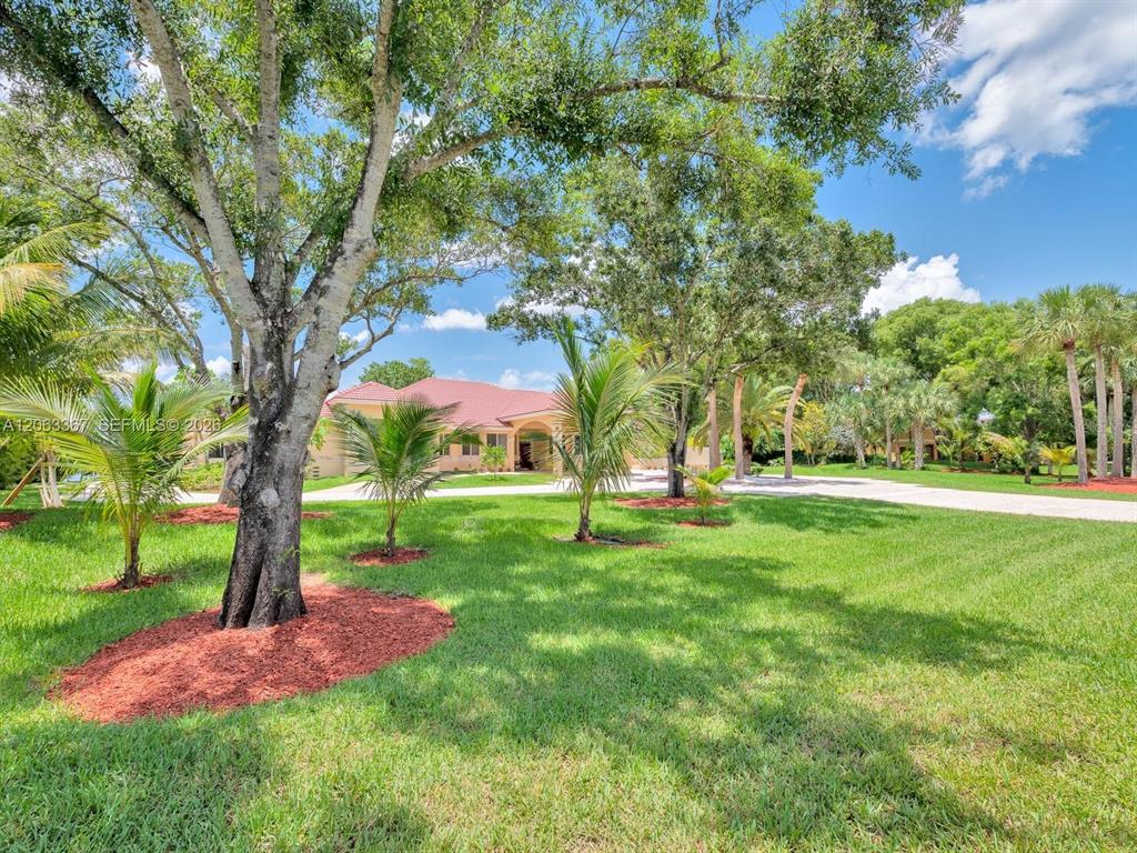 A single-story house with a red tile roof sits behind a large, grassy front yard — 2710 WALKERS WAY, WESTON, FL