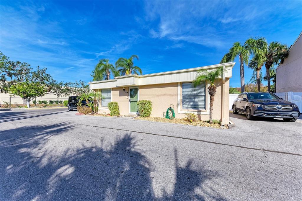 A single-story tan stucco building with a green front door and a parked Mercedes-Benz — 6336 7TH AVENUE W UNIT 6336, BRADENTON, FL