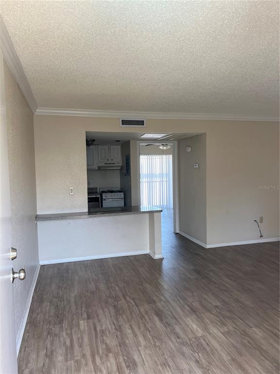 An open-concept living area features wood-look flooring, a kitchen pass-through counter, and a dining area — 136 BLUE POINT WAY UNIT 310, ALTAMONTE SPRINGS, FL