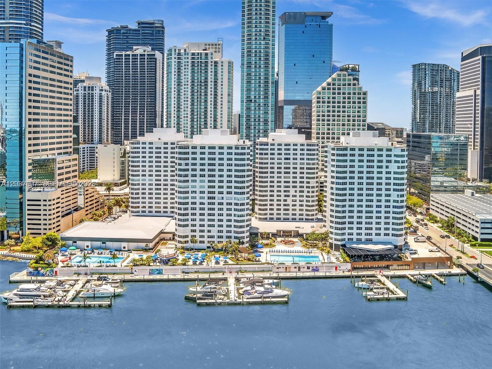 An aerial view of a waterfront apartment complex with a marina and city skyline — 905 Brickell Bay Dr # 623, Miami FL 33131, MIAMI, FL