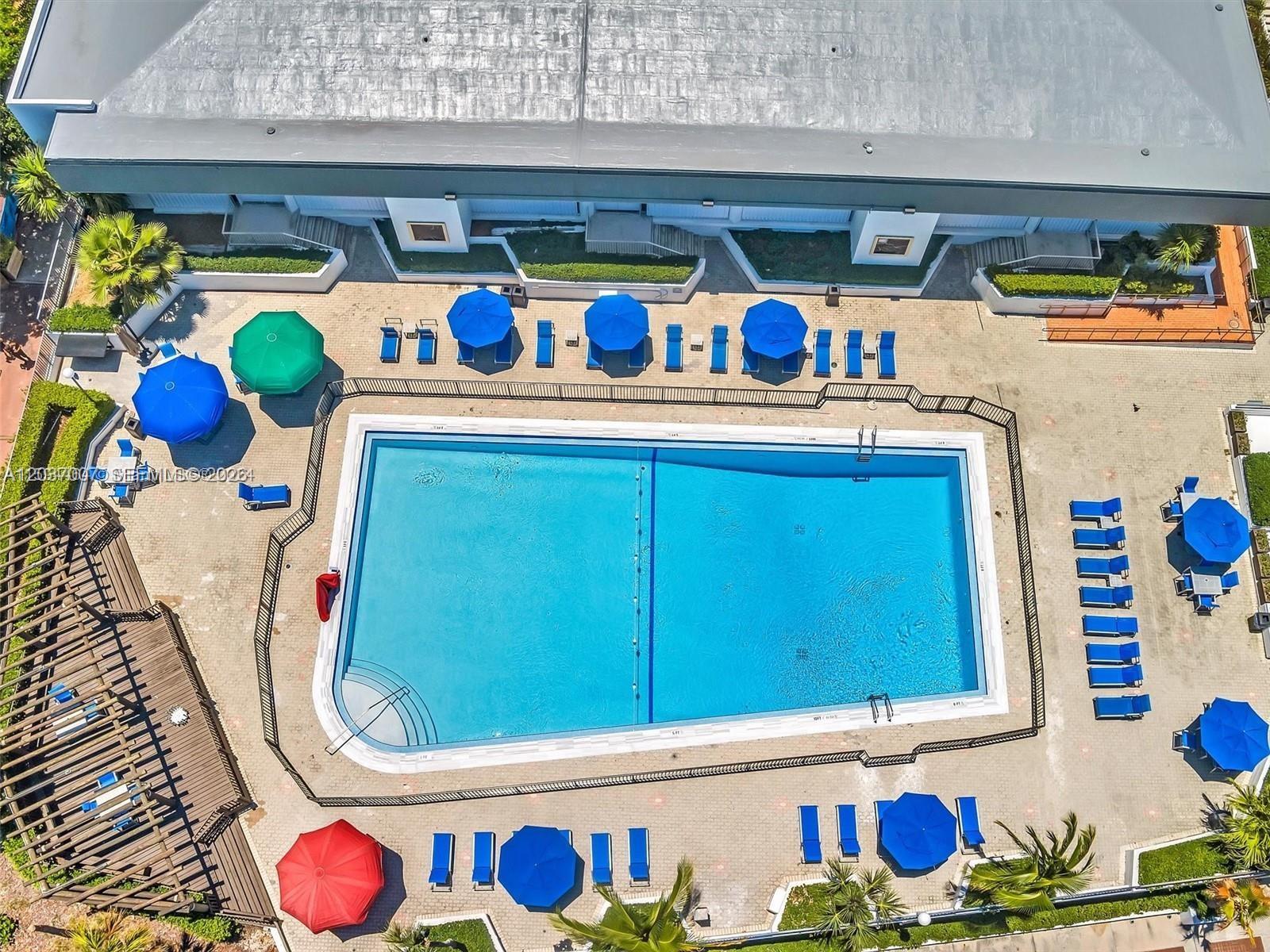 An aerial view shows a rectangular swimming pool surrounded by lounge chairs and patio umbrellas — 905 Brickell Bay Dr # 623, Miami FL 33131, MIAMI, FL