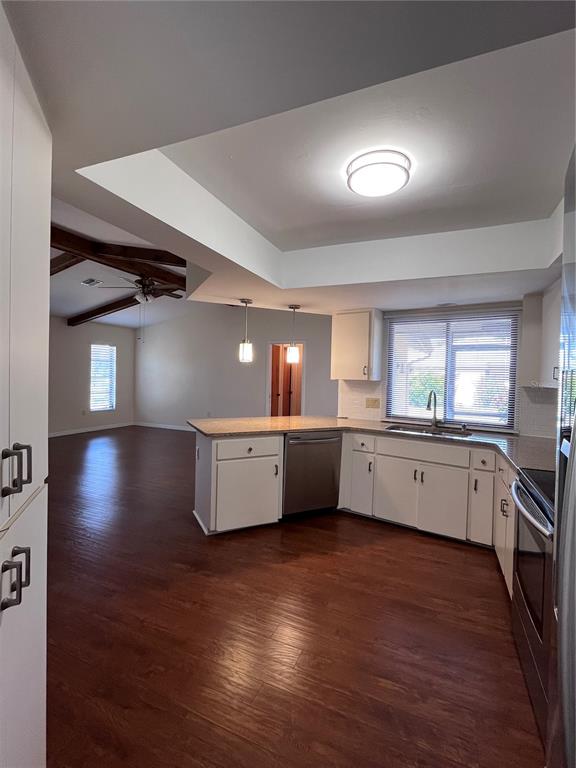 A kitchen with white cabinets and stainless steel appliances opens into a living area — 5816 MONROE ROAD, VENICE, FL