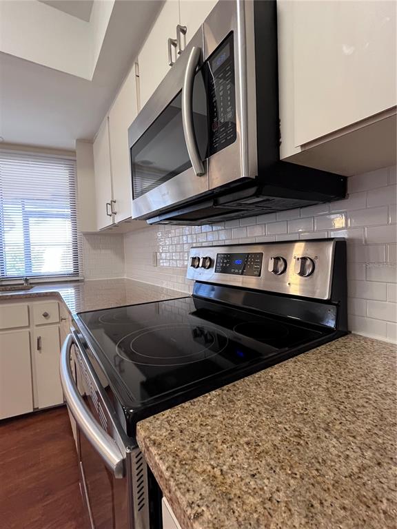 A kitchen features stainless steel appliances, white cabinets, a granite countertop, and a subway tile backsplash — 5816 MONROE ROAD, VENICE, FL