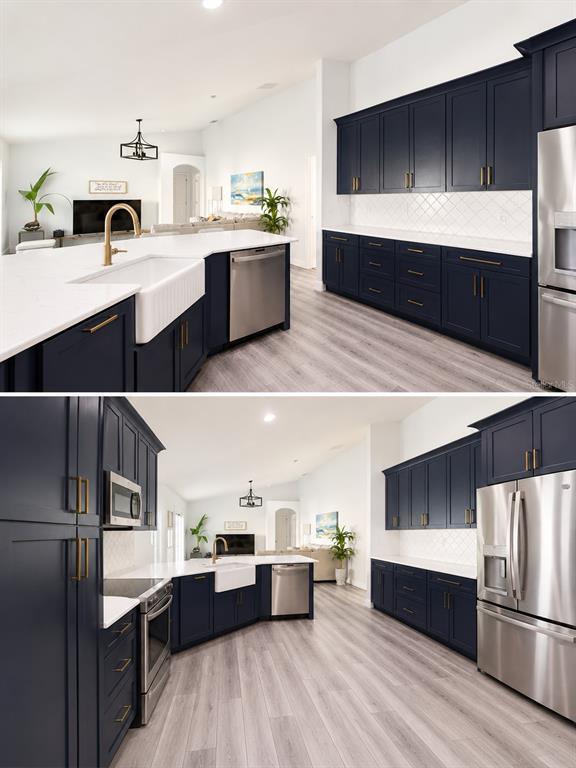A kitchen features navy blue cabinets, white countertops, stainless steel appliances, and light wood flooring — 2526 HOLLY BERRY CIRCLE, CLERMONT, FL