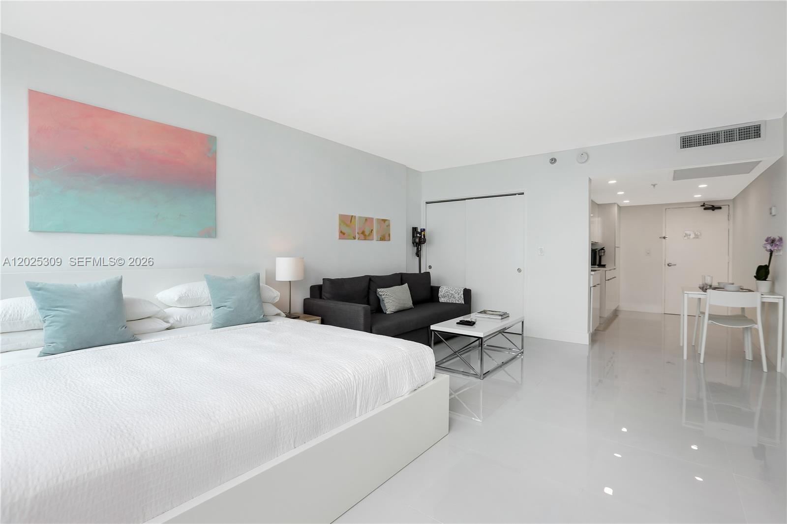A studio apartment features a bed, a sofa, a coffee table, and a dining area — 5445 Collins Ave # 928, Miami Beach FL 33140, MIAMI BEACH, FL