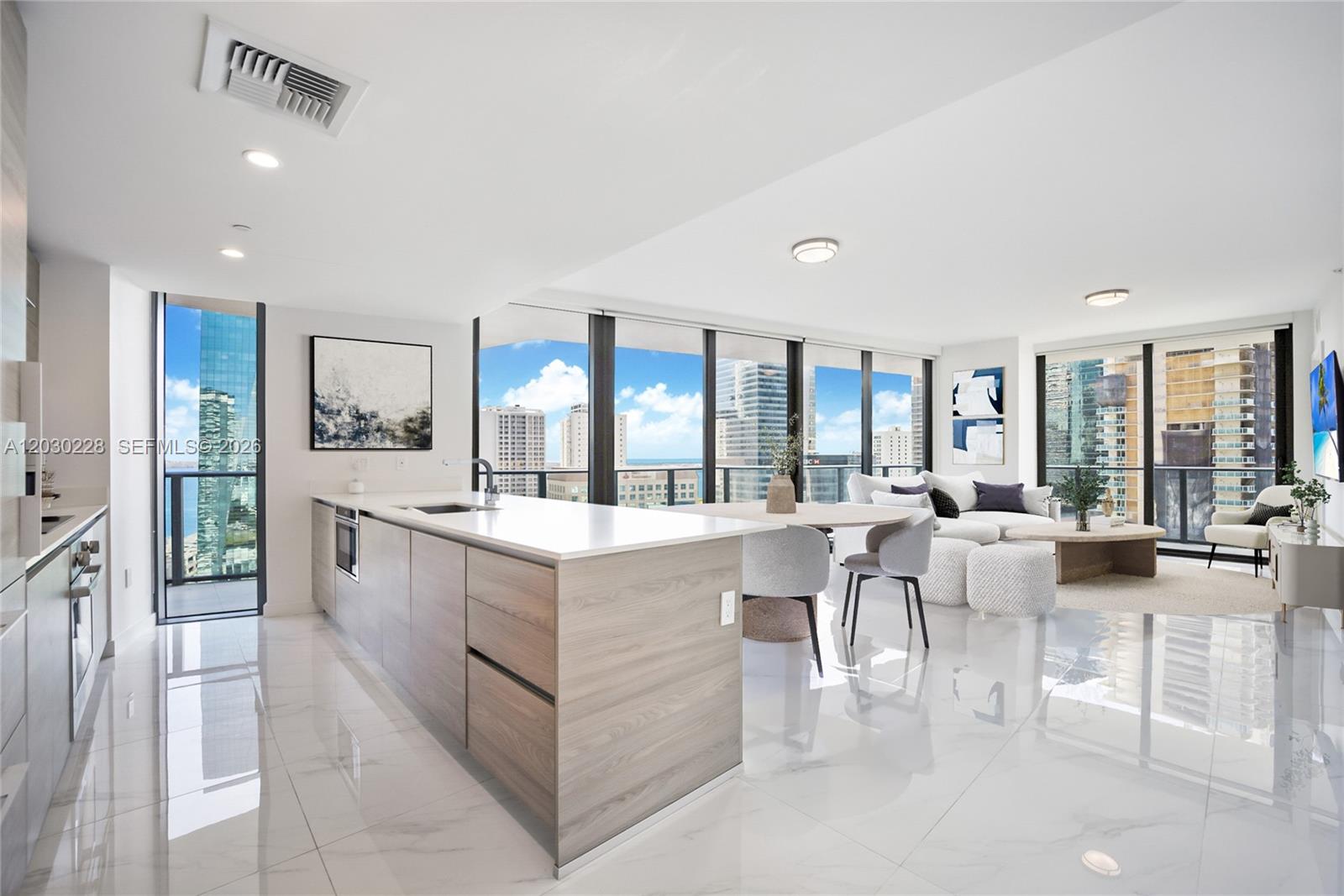 A modern open-concept kitchen and living area with light wood cabinetry and floor-to-ceiling windows — 1300 S Miami Ave # 1705, Miami FL 33130, MIAMI, FL