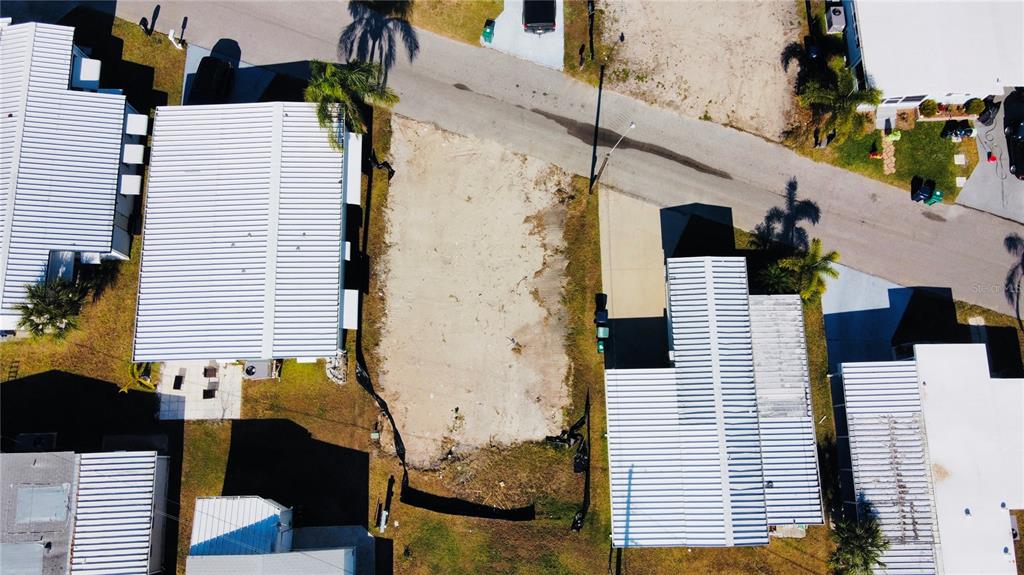 An aerial view shows a vacant, rectangular dirt lot situated between two existing mobile homes — 291 NASSAU DRIVE, PALMETTO, FL