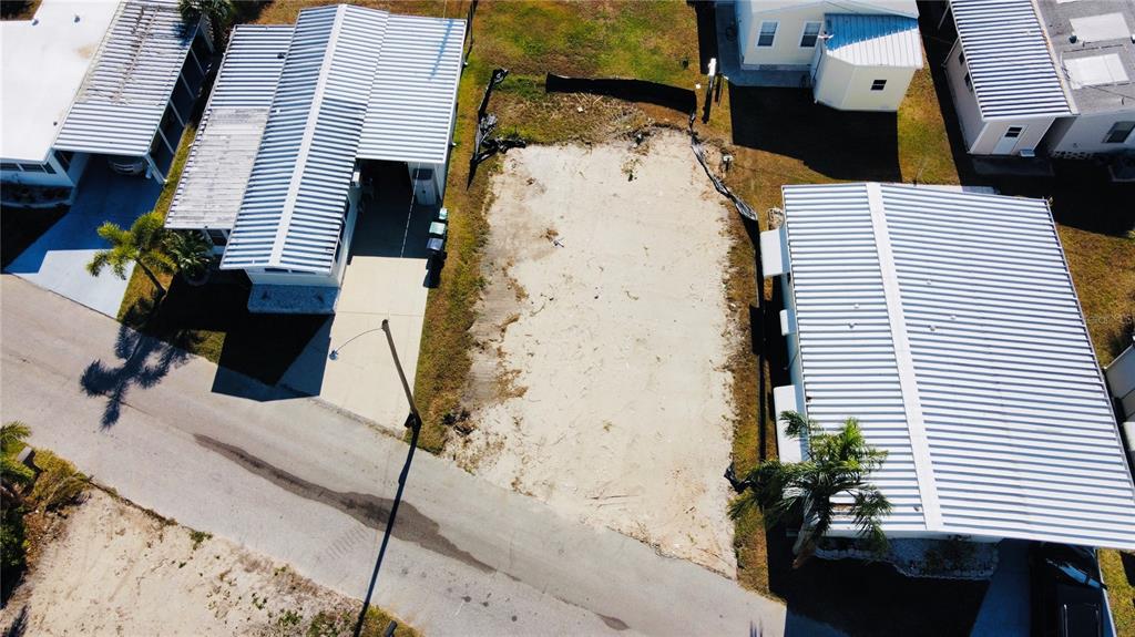 An aerial view shows a vacant, sandy residential lot situated between two manufactured homes — 291 NASSAU DRIVE, PALMETTO, FL