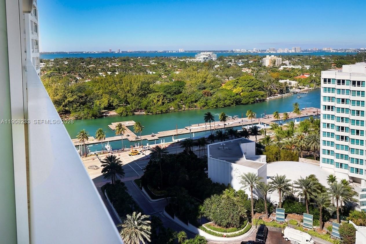 A high-angle view shows a waterway, palm trees, and surrounding buildings from a balcony — 4391 Collins Ave # 1703, Miami Beach FL 33140, MIAMI BEACH, FL