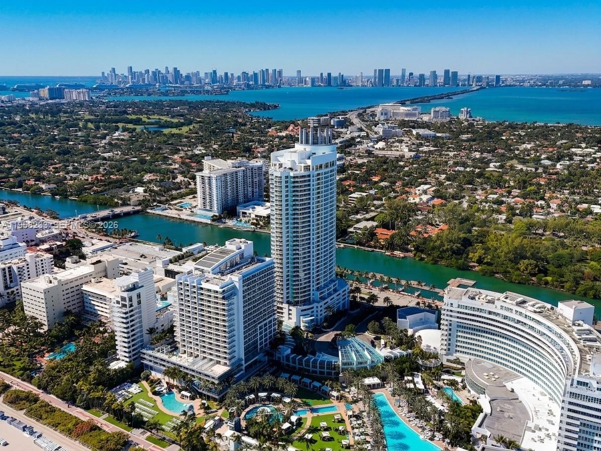 An aerial view of a tall residential tower surrounded by resort-style pools and coastal waterways — 4391 Collins Ave # 1703, Miami Beach FL 33140, MIAMI BEACH, FL
