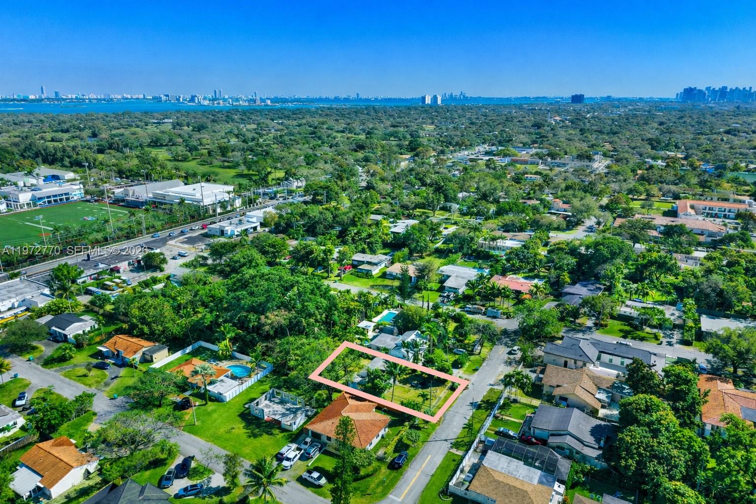 An aerial view shows a rectangular residential lot outlined in pink within a suburban neighborhood — 10821 NE 5th Ave, Miami FL 33161, MIAMI, FL