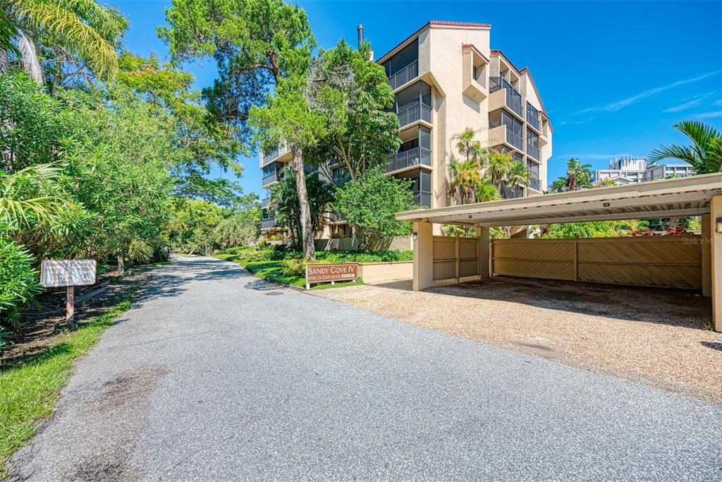 An exterior view of a multi-story apartment building with a covered parking area — 4900 OCEAN BOULEVARD UNIT 501, SARASOTA, FL