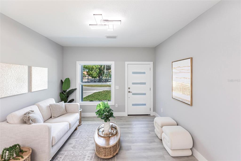 A living room features a white sofa, oval coffee table, two ottomans, and a front door — 12123 PLATANO DRIVE, PUNTA GORDA, FL