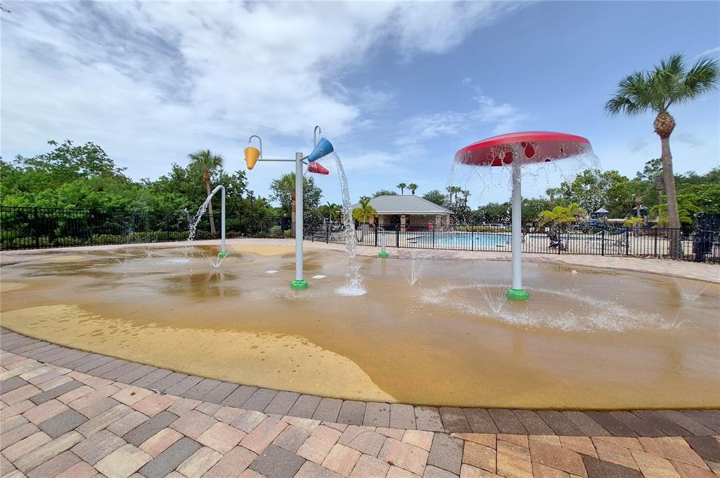 A splash pad area features water-spraying structures and a mushroom fountain on a paved deck — 9310 BLUEBERRY ASH CIRCLE, RIVERVIEW, FL