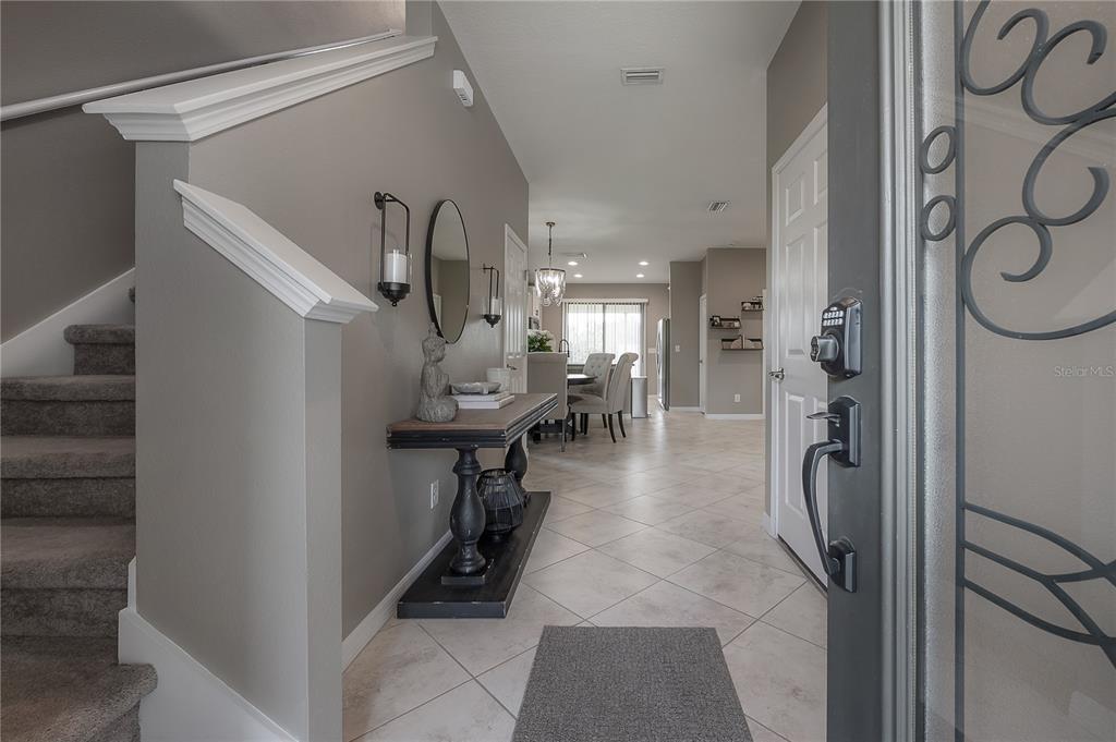 A view from an entryway looking toward a dining area with tile floors and stairs — 9310 BLUEBERRY ASH CIRCLE, RIVERVIEW, FL