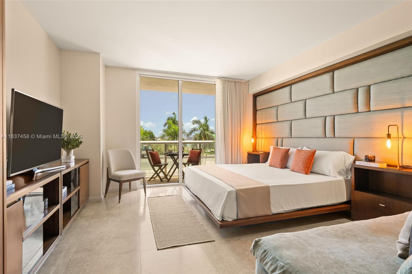 A modern bedroom features a platform bed, upholstered headboard, and a balcony with palm trees — 50 Biscayne Blvd # 411, Miami FL 33132, MIAMI, FL