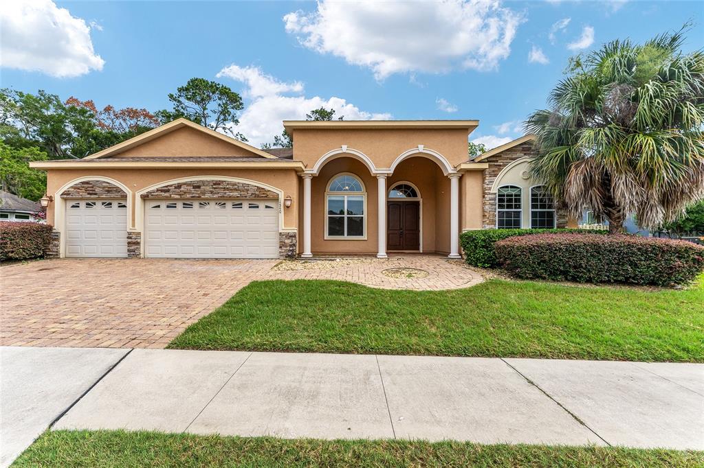 A single-story house with a two-car garage, arched entryway, and stone accents on the facade — 14540 NW 27TH PLACE, NEWBERRY, FL