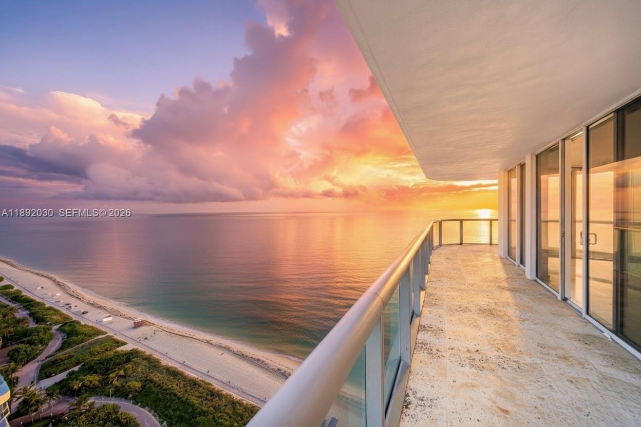 A balcony with stone flooring overlooks the ocean during a vibrant sunset — 6365 Collins Ave # 2901, Miami Beach FL 33141, MIAMI BEACH, FL