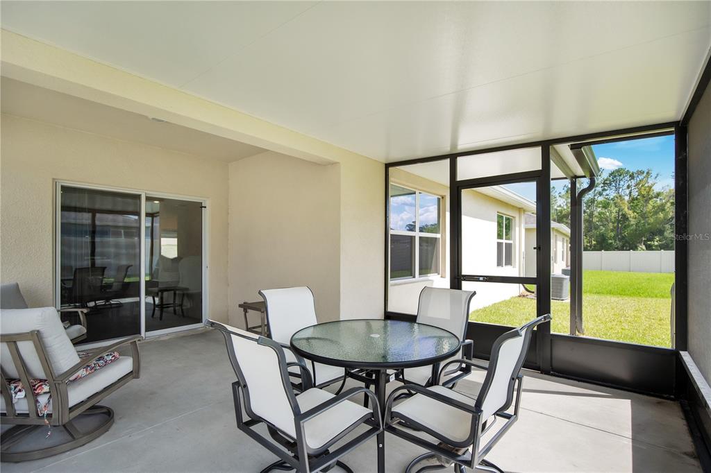 A covered patio with a screen enclosure, outdoor furniture, and a view of the backyard — 3768 BOTANICAL WAY, SANFORD, FL